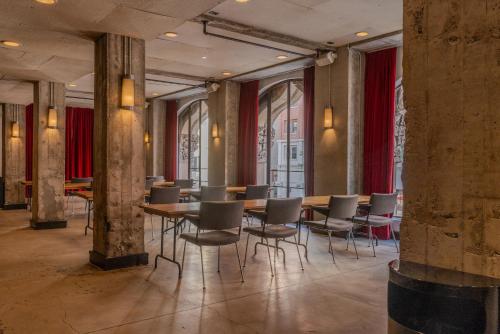 a dining room with tables and chairs and red curtains at Stile Downtown Los Angeles By Kasa in Los Angeles