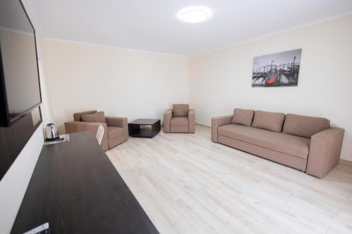 a living room with two couches and a table at Fantasia Hotel in Polyana