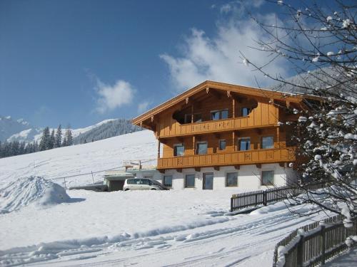 a large wooden building in the snow at Apartment Galtenberg in Alpbach