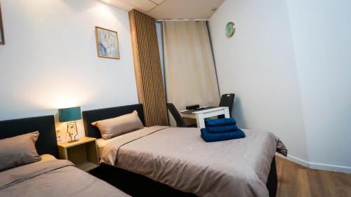 a room with two beds and a table with a mirror at GLOW Apartment in Magdeburg