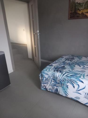a bedroom with a bed with a blue and white blanket at Domek Pod Prehybą -Agroturystyka in Gaboń