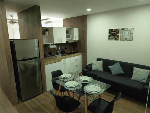 a living room with a couch and a table with chairs at Moderno 1BR sauna gimnasio alberca a cuadras de la 5ta av centro in Playa del Carmen