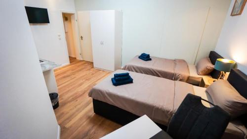 a small room with two beds and a couch at GLOW Apartment in Magdeburg