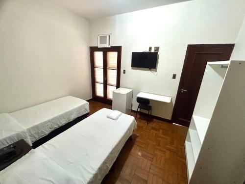 a small room with two beds and a sink at Hotel Jaú by Easy Hotéis in Jaú