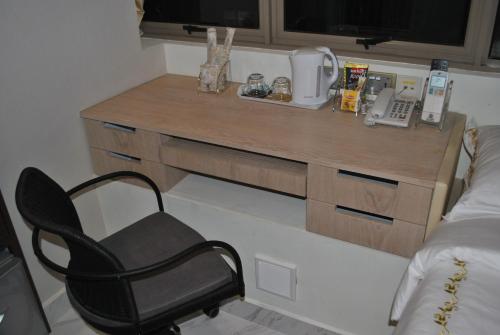 a desk in a room with a chair and a bed at Jayleen Clarke Quay Hotel in Singapore