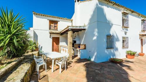 a white house with a table and chairs on a patio at Casa del Tigre Gaucín by Ruralidays in Gaucín