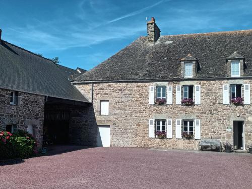 ein großes Backsteingebäude mit weißen Fenstern in der Unterkunft Chambres d'hôtes Au bout du Monde in Auderville