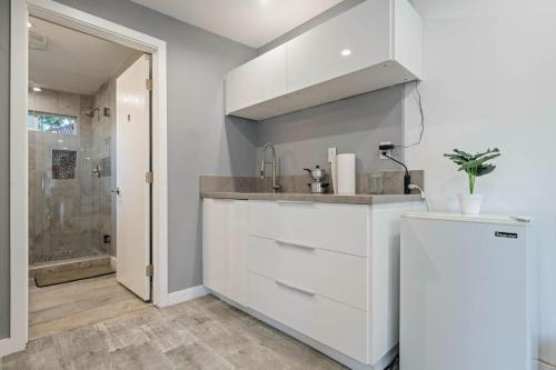 a white kitchen with a sink and a shower at Middlebury Heights with Pool in Los Angeles