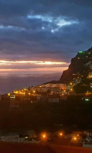 a view of a city at night with a mountain at Paraíso Pico da Torre in Câmara de Lobos