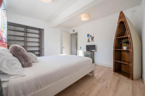a white bedroom with a large bed and a television at Middlebury Heights with Pool in Los Angeles