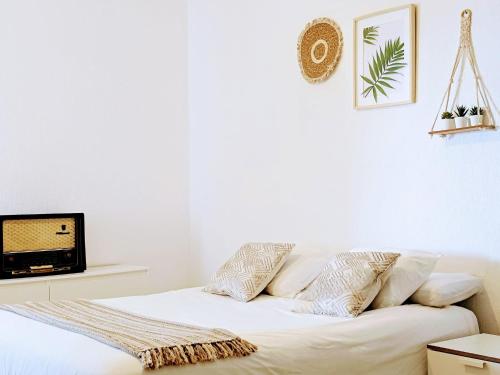 a white bed with pillows and a tv in a room at Seaview Apartment, Playa Chica, Las Gaviotas, Apartamento 311 in Santa Cruz de Tenerife