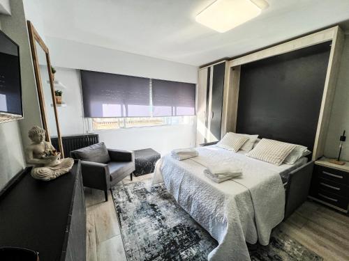 a bedroom with a large bed and a chair at The Olive Loft in Vigo