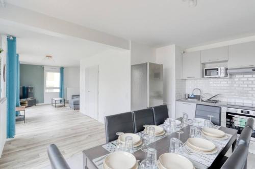 une salle à manger avec une table et des chaises et une cuisine dans l'établissement Kabala - ParisNord Villepinte CDG StadedeFrance, à Bondy