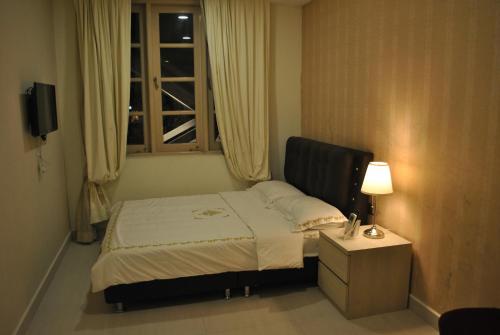 a small bedroom with a bed and a window at Jayleen Clarke Quay Hotel in Singapore