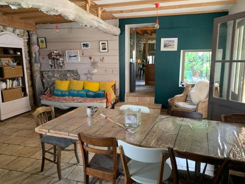 ein Wohnzimmer mit Tisch und Couch in der Unterkunft Notre maison de famille, la maison de shaoni in Saint-Romans