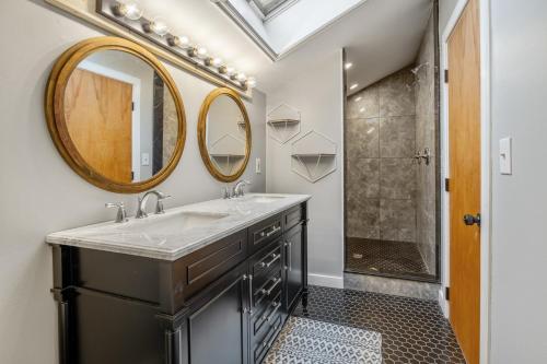 ein Badezimmer mit Waschbecken, Spiegel und Dusche in der Unterkunft Minutes to Sun Bowl and Stratton Base Lodge in Jamaica