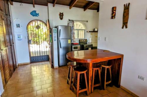 a kitchen with a wooden table and a refrigerator at Tico Tiki Vacation Villa, 3 Bedroom in Sámara