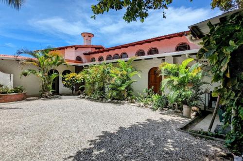 an exterior view of a house with a red roof at Tico Tiki Vacation Villa, 3 Bedroom in Sámara