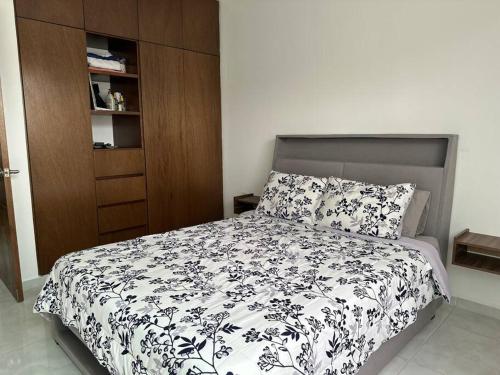 une chambre avec un lit avec une couette noire et blanche dans l'établissement Casa Lomas de la rioja climatizada y con wifi para hasta 10 personas, à Guadalupe