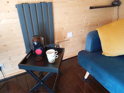 a side table with a coffee cup on it next to a bed at Adventure Cabin Retreat 'The CabAnne' No Shower in Dublin