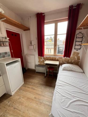 une chambre avec un lit, un bureau et une fenêtre dans l'établissement Petit nid ensoleillé, à Rouen