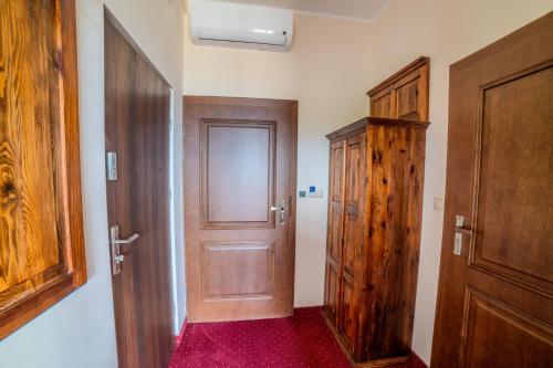 a hallway with a wooden door and a wooden cabinet at Pensjonat Sekuła*** in Bukowina Tatrzańska