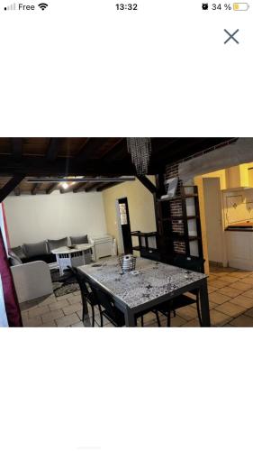 Un comedor con una mesa y un sofá. en Maison 5mn gare sncf, en Saint-Doulchard
