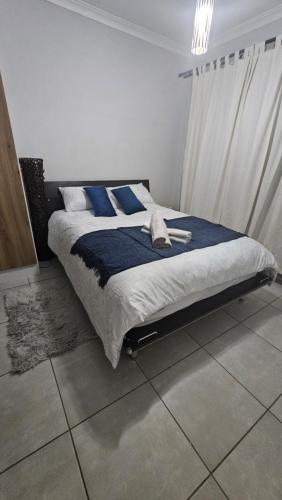 a bedroom with a bed with blue pillows at The Blyde Crystal Lagoon 2 Bedroom Penthouse 1336 in Pretoria