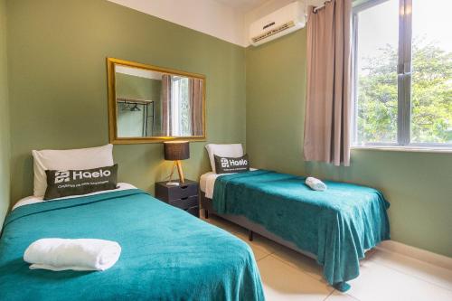 Habitación verde con 2 camas y espejo. en 3Hab Conforto: 100m de la Playa Copacabana-Ipanema, en Río de Janeiro