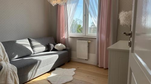 a living room with a couch and a window at Apartament La Bella klimatyzacja, garaż podziemny, Fv in Suwałki