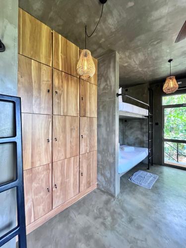 a room with wooden cabinets and a bed at Sea View Hostel Hiriketiya in Dickwella