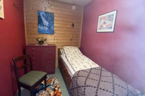 a small bedroom with a bed and a chair at Cozy apartment near city center and nature in Kristiansund
