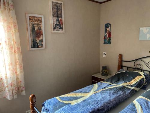 a bedroom with a bed and pictures on the wall at Cozy apartment near city center and nature in Kristiansund