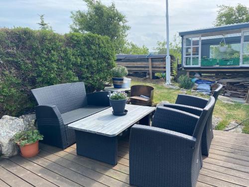 a patio with wicker chairs and a table on a deck at Cozy apartment near city center and nature in Kristiansund