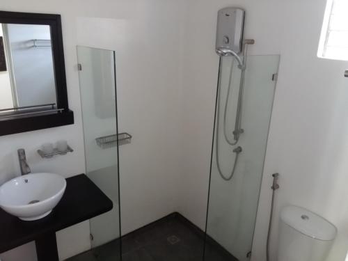 a bathroom with a glass shower and a sink at Sunset Beach Resort by RF at SanVicentePalawan OPC in San Vicente