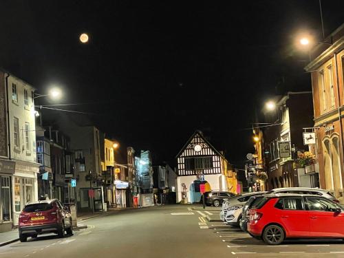 a city street at night with cars parked at Cartway Apartment in Bridgnorth