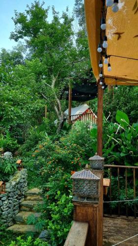 a garden with a wooden bench and a tree at Xieng Retreat in Hanoi