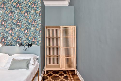 a bedroom with a blue wall with a wooden book shelf at Bligny Zero by Apartments To Art in Turin