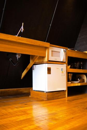 a microwave sitting on top of a refrigerator under a counter at Pousada Morada das Araucarias in Pôrto Vitória