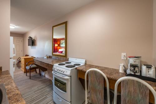 a kitchen with a stove and a counter with a mirror at Sahara Courtyard Inn Penticton in Penticton