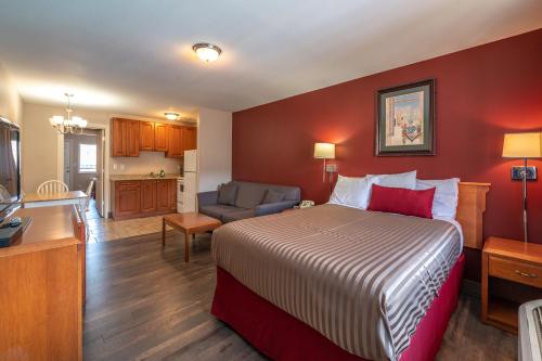 a hotel room with a bed and a kitchen at Sahara Courtyard Inn Penticton in Penticton