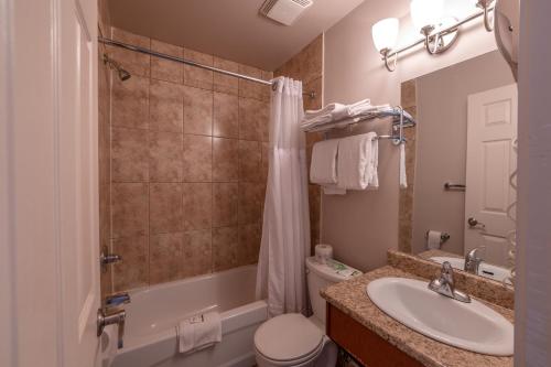 a bathroom with a sink and a toilet and a shower at Sahara Courtyard Inn Penticton in Penticton