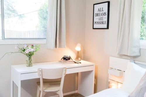 a desk in a bedroom with a bed and a table and chair at Lovely Wooden Home in Kirkland, Walk to Beach Park in Kirkland