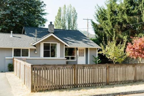 a house with a wooden fence in front of it at Lovely Wooden Home in Kirkland, Walk to Beach Park in Kirkland