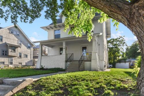 a white house with a tree in front of it at Luxury Midtown Home with Historic Charm in Omaha