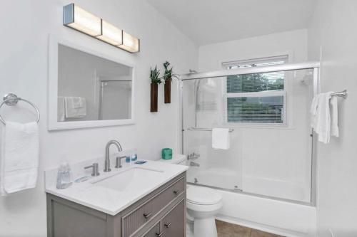 a white bathroom with a sink and a shower at Blue Park Nest - 3BR 2BA in West Columbia