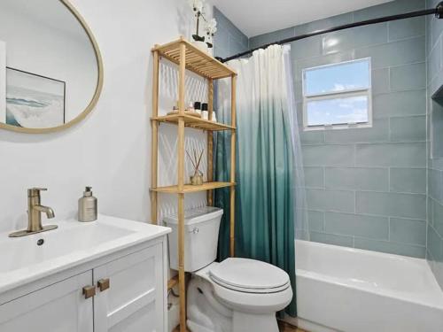 ein Badezimmer mit Toilette, Waschbecken und Spiegel in der Unterkunft Coastal Hideaway in Lake Worth