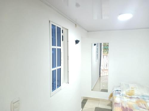 a white room with two windows and a couch at Habitación Independiente El paraíso - Cerca al Gran Malecón del Rio-Barranquilla in Barranquilla