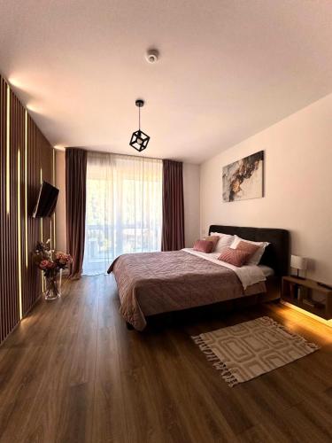 a bedroom with a bed and a large window at Alpine Line Studio with pool & spa in Sinaia