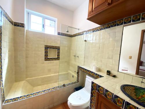 a bathroom with a shower and a toilet and a sink at Zihil Ha Hotel in Playa del Carmen